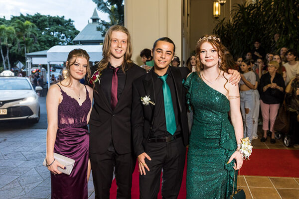 Two young couple dressed up on red carpet for school formal arrivals
