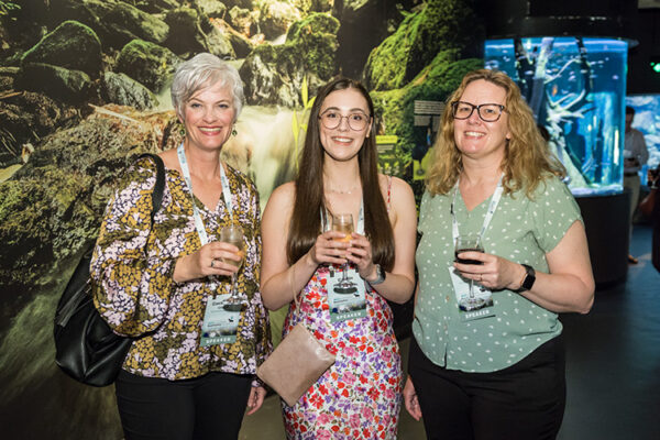 Group photo of delegates enjoying a drink at conference function at an aquarium