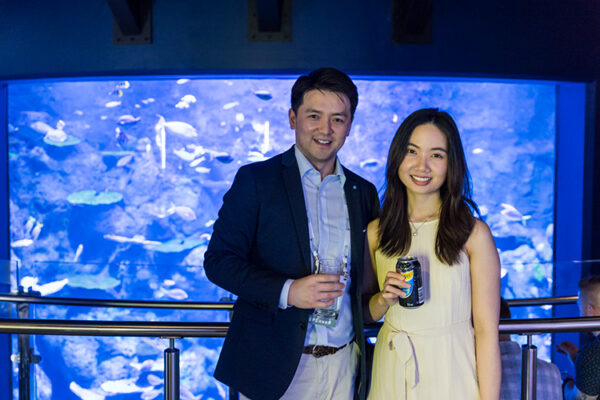 Group photo of delegates enjoying a drink at conference function at an aquarium