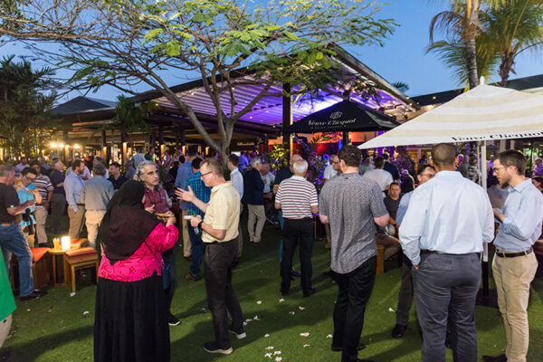 Delegates networking at conference social event at bar