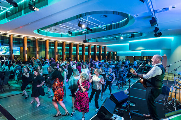 Delegates on the dance floor and band playing at conference dinner