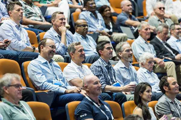 Delegates seated in auditorium watching a session speaker