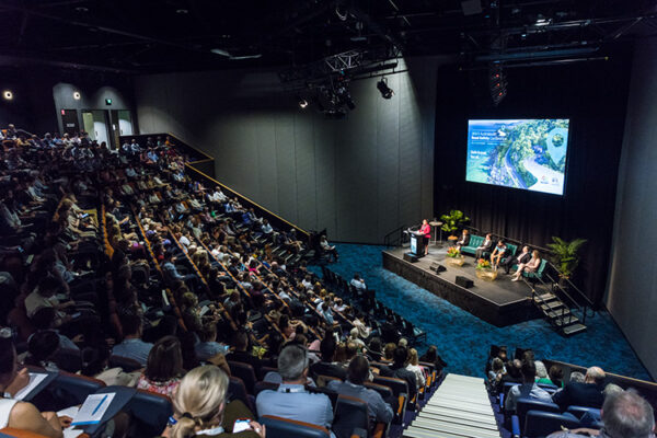 View of delegates watching a speaker presentation in auditorium at conference
