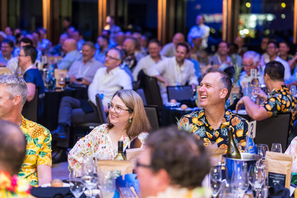 Delegates laughing at speaker at a conference dinner