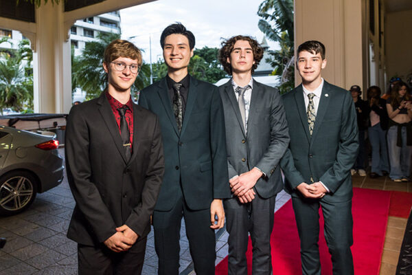 Male students at school formal photographed on red carpet arrivals