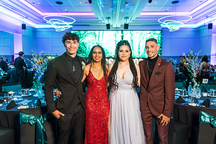 Student couples dressed up for senior formal with ballroom background