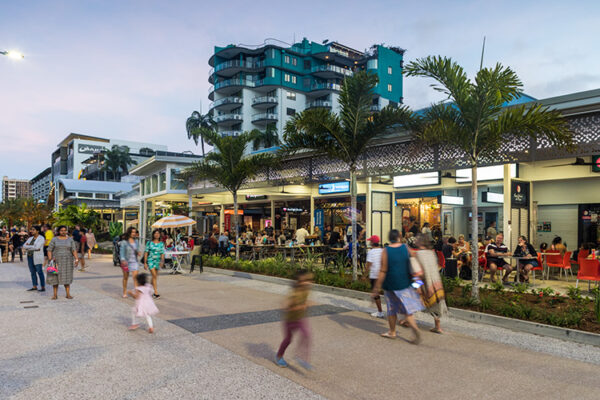 People walking along Esplanade roadway beside busy restaurant diners